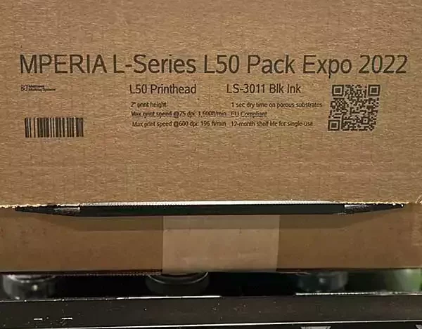 Cardboard box with bar codes and text printed on it in black ink.