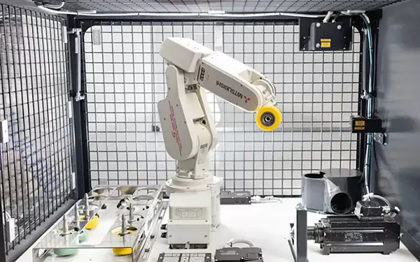 Industrial robot in a safety cage.