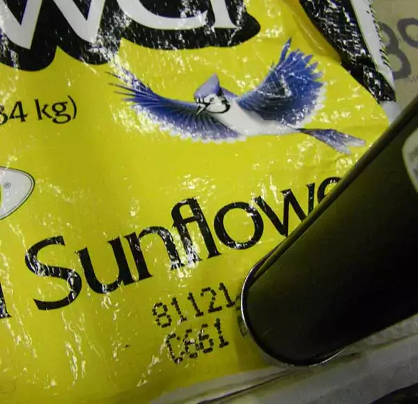 A Matthews V-Series DOD valvejet printer creates a large character mark on a filled bag of wild bird sunflower seeds. The printer’s long-throw distance accommodates the bag’s curved surface.