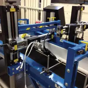 Custom-engineered industrial automation platform featuring multiple tool heads, positioning equipment, and integrated controls within a blue steel framework.