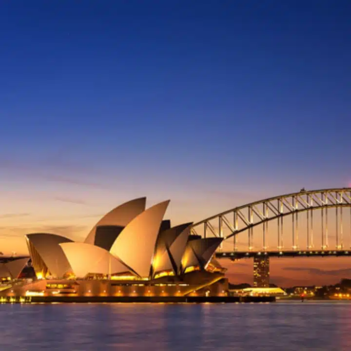Australia - Sydney Opera house view at twilight time with vivid sky and illumination on the bridge.