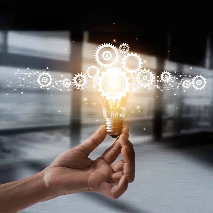 Concept image of innovation in manufacturing featuring a glowing lightbulb with interconnected gears representing engineering and problem-solving.
