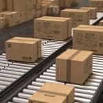 Corrugated cardboard box cases on a conveyor. The boxes are marked in black ink with various graphics, barcodes, and text to make on-demand case printing, carton marking and case labeling for custom package boxes.