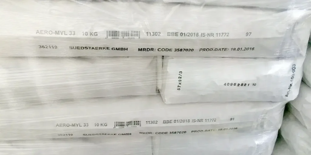 Plastic-wrapped industrial bags marked with product details, barcodes, batch codes, and production dates.