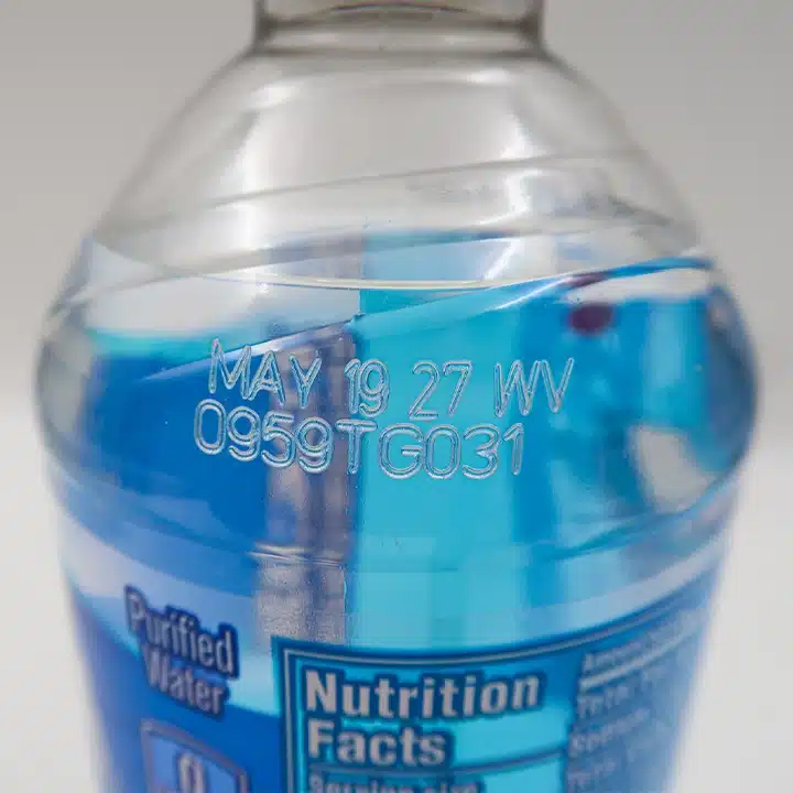 High-contrast date and lot code printed on a plastic beverage bottle.