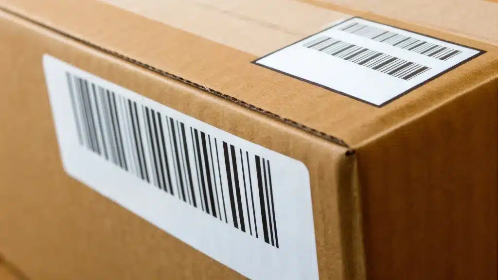Close-up of barcode labels applied to the top and side of a cardboard box.