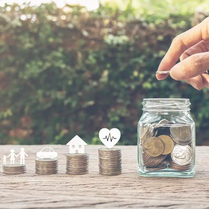 Coins being placed into a savings jar with icons representing family, transportation, housing, and healthcare benefits.
