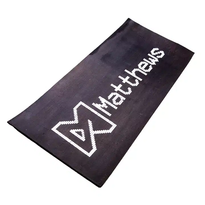 Dot matrix logo and text printed on a rubber conveyor belt for industrial product identification.
