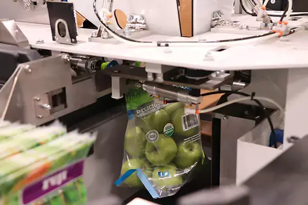 Apple pouch marked by L-12 getting filled at Haley Manufacturing Olympic Fruit.