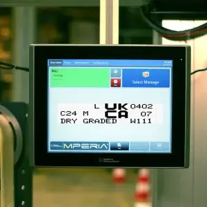 Matthews Marking Systems MPERIA touchscreen controller displaying a UKCA marking alongside product identification codes for lumber manufacturing.