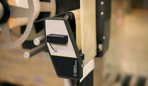 Close-up of a Matthews Marking Systems A-Series automatic pallet label applicator used for accurate label placement in industrial packaging operations.