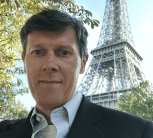 Portrait of Steven Keddie, Senior Director of GS1 Standards, standing outdoors with the Eiffel Tower in the background.